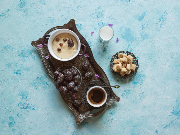 Śniadanie z datami, kawą i zdrową owsianką na niebieskim stole - Zdjęcie, obraz