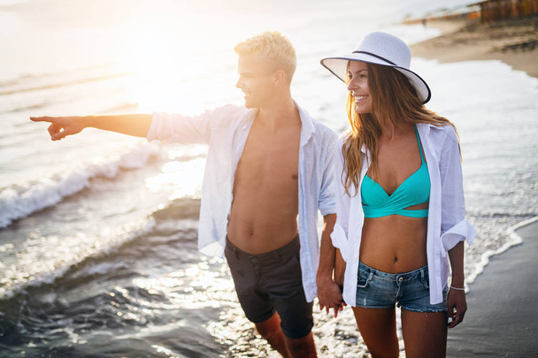 Happy cheerful couple having fun on a tropical beach at sunset. Concept about romantic vacation - Фото, зображення