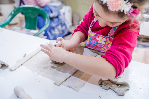 Pieni tyttö keramiikka työpaja muotoiluun Clay maljakko
 - Valokuva, kuva