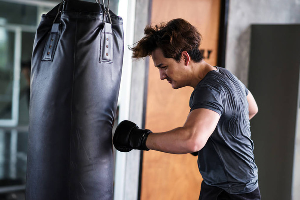 Jonge man Punch Big Bag in fitness gym - Foto, afbeelding