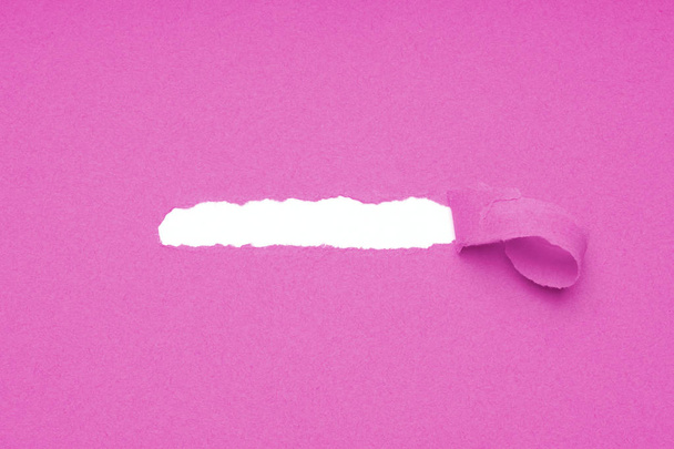 agujero roto en papel rosa para revelar espacio oculto de copia
 - Foto, imagen
