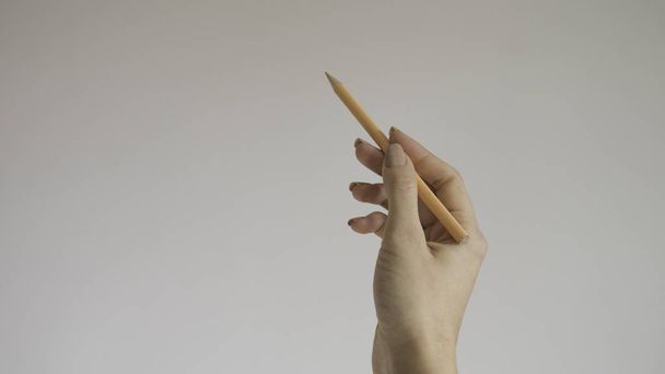  Mano de mujer sosteniendo un lápiz de color de madera sobre fondo aislado
 - Foto, imagen