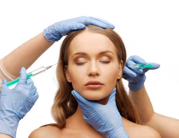Woman face and beautician hands with syringe - Photo, Image