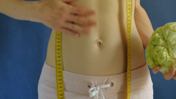 Frau mit flachem Bauch. Nahaufnahme auf blauem Hintergrund. gesunde Ernährung, Fitness - Filmmaterial, Video