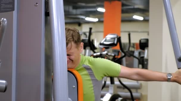  El hombre hace un ejercicio de mariposa en el simulador en un estilo de vida studio.healthy fitness. Fitness y Deporte
 - Imágenes, Vídeo