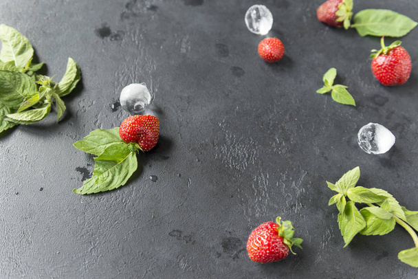 mint leaves, strawberry with ice pieces on black background - Fotografie, Obrázek