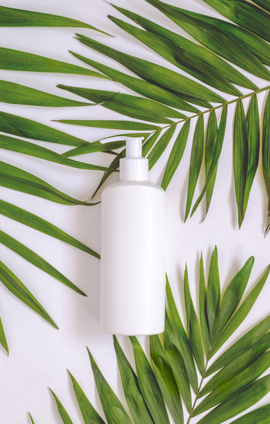 Creativos envases cosméticos minimalistas maqueta de plástico con hojas de palma. Mock-up para branding y etiqueta
. - Foto, imagen