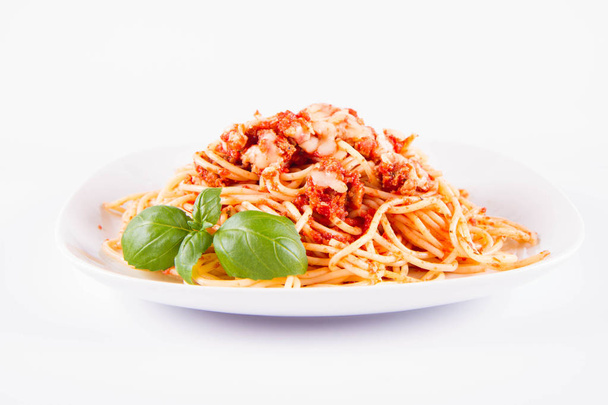 Спагетти болоньезе с расплавленным сыром пармезан, украшенный базиликом на белом фоне
 - Фото, изображение