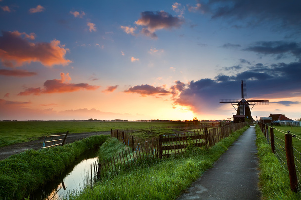 Salida del sol detrás del molino de viento, Holanda
 - Foto, Imagen