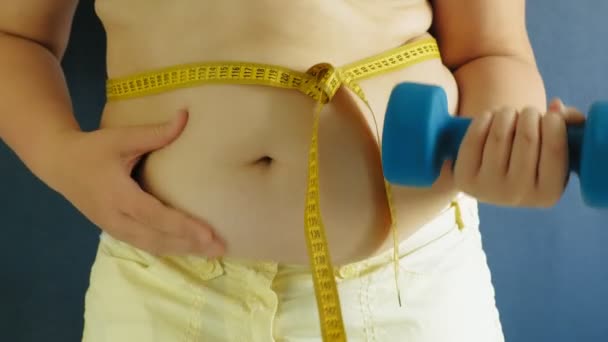 青い背景に脂肪の女性の腹クローズアップ - 映像、動画