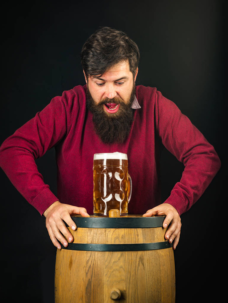 Biersoorten en stijlen. Bier in Duitsland. Portret van knappe jonge man die een tapbier proeft. Duitsland-Beieren. - Foto, afbeelding