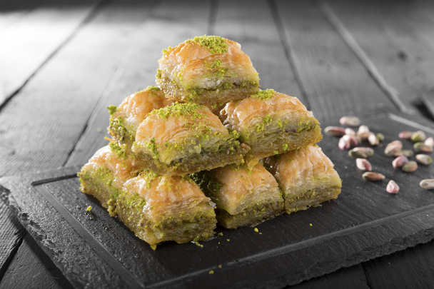 vue rapprochée de la boulangerie maison savoureuse avec des noix sur une table en bois. Dessert Ramadan turc Baklava aux pistaches  - Photo, image