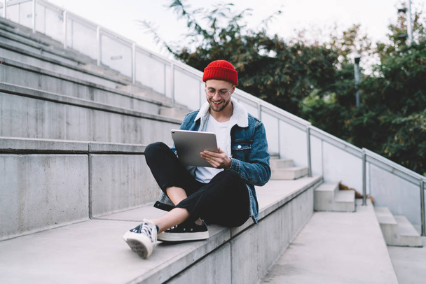 Happy hipster blogger typing content text for publicate and attract new followers to own website for millenials using 4g wireless on modern digital tablet, concept of online chatting and messaging - Photo, image