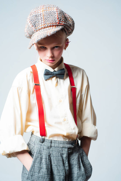 jazz step fashion. vintage english style. retro fashion model. vintage charleston party. suspender and bow tie. old fashioned child in checkered beret. teen girl in retro male suit. In her own style - Фото, зображення