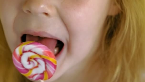 Little girl with a lollipop on a Yellow background. Close up portrait - Footage, Video