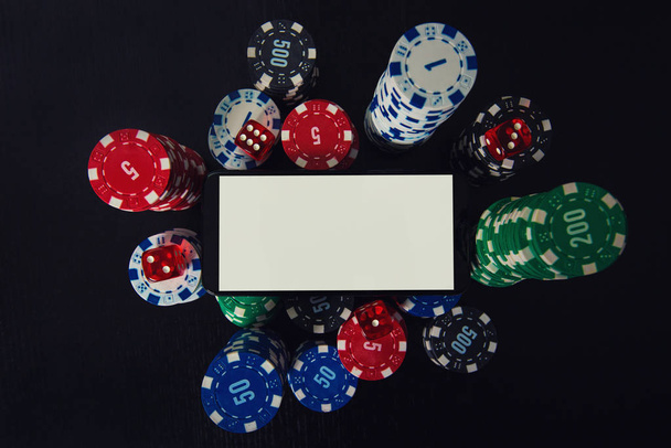Online casino gokken concept. Smartphone leeg scherm op chips - Foto, afbeelding