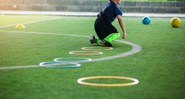 selektivní zaměření na dětský fotbalový hráč joggingu a skok na prsten La - Fotografie, Obrázek