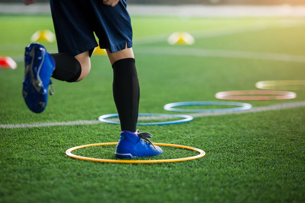 子供サッカー選手ジョギングとリングラでジャンプに選択的な焦点 - 写真・画像