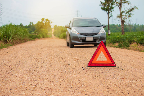 Rode waarschuwingsdriehoek. Focus op rode driehoek!, naast landelijke weg. - Foto, afbeelding