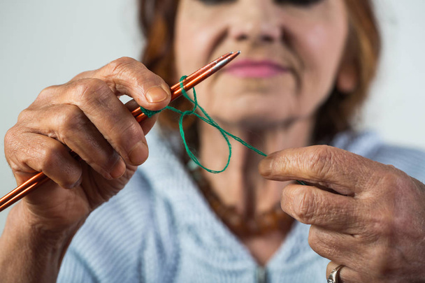 Knitting. Elegant elderly woman holding needle and wool in hand and do knitting during her leisure. Seniour lady on retirement. Knitwork and hand made for sale. Business idea for pensioners. - Photo, Image