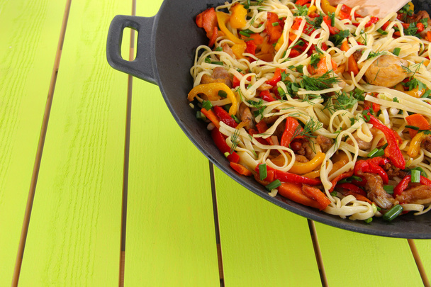 Noodles with vegetables on wok on wooden background - Fotoğraf, Görsel
