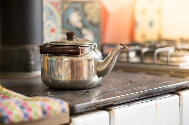 Cooking tea in winter time: rustic iron tea cooker - Foto, imagen