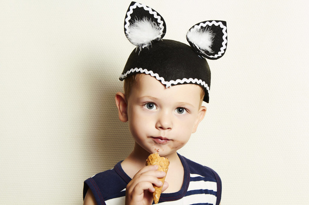 Child. cute kid boy eating ice cream in studio.masquerade - Photo, Image
