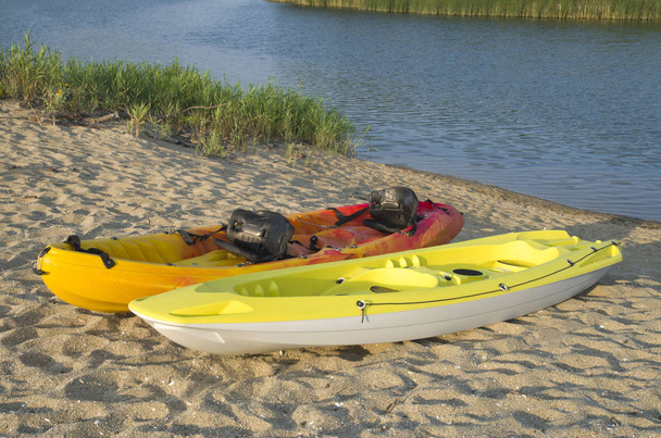 Two types of kayak two-seat sit-on-top  on the sandy bank of the - Photo, Image