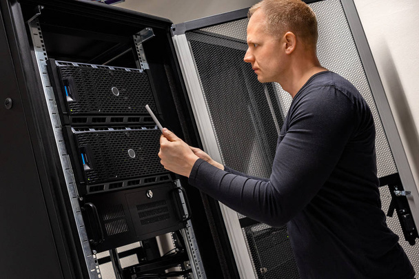 IT Support Holding Digital Tablet Analyzing Servers And Network In Datacenter - Photo, Image