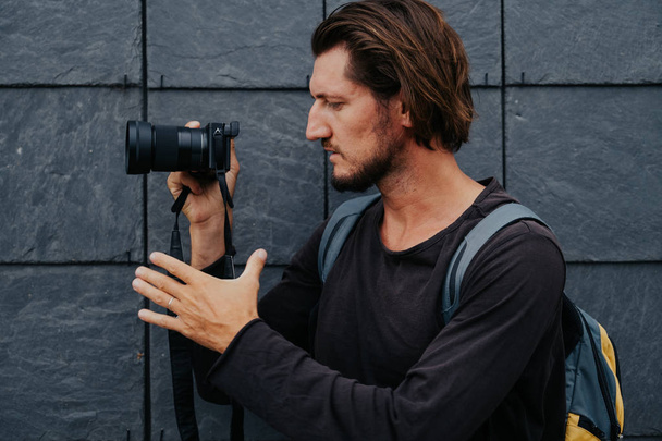 Young hipster photographer with camera and backpack - Photo, image