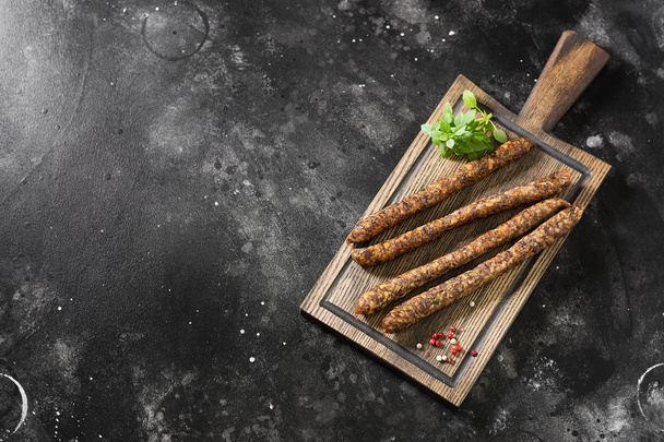 Smoked sausages on a wooden Board. Sausages to beer. Dark background - Фото, зображення