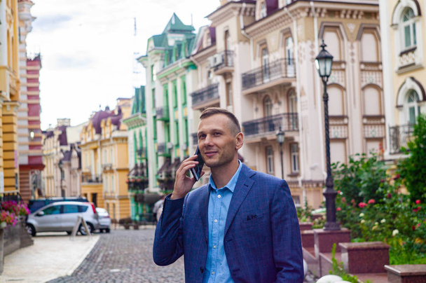 Confident young businessman using cell phone in the city.  - Фото, зображення
