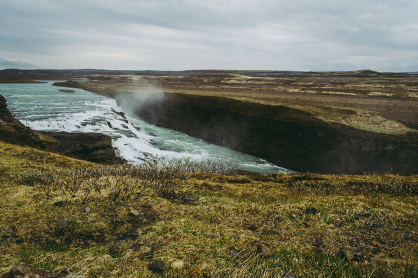 Gullfoss, uno de los destinos más bellos de Islandia. Hierba verde pálido y cascadas con agua turquesa
. - Foto, imagen