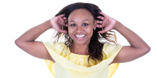 ευτυχής νεαρή γυναίκα αμερικανική αφρικανική γέλιο με τα χέρια πίσω από το κεφάλι σε λευκό φόντο - Φωτογραφία, εικόνα