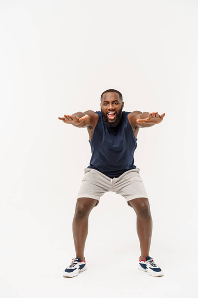 African sport man exercising and stretching on white background - 写真・画像