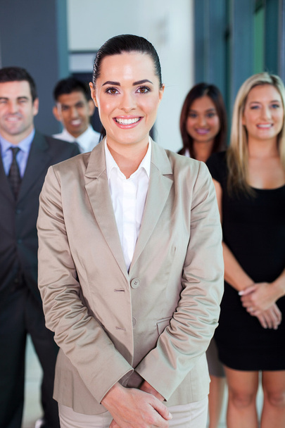 vrouwelijke business leider met team op achtergrond - Foto, afbeelding