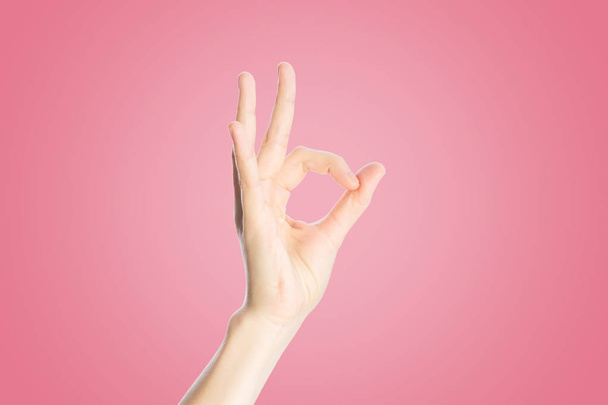 Positive gesture on a pink background. Hand show okay sign, close up - Fotografie, Obrázek