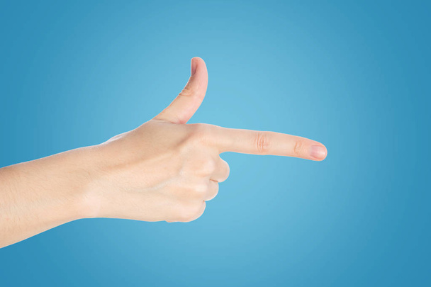 Apontando o dedo sobre um fundo azul. Mão mostrar gesto direção, close-up
 - Foto, Imagem
