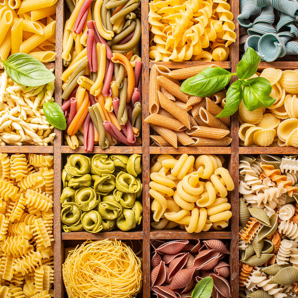 Assorted colorful italian pasta in wooden box - Foto, imagen