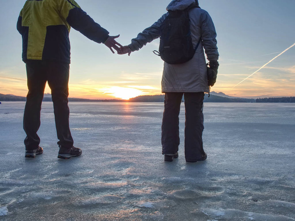 Ζευγάρι έχει τη διασκέδαση κατά τη χειμερινή βόλτα στον πάγο της κατεψυγμένη λίμνη - Φωτογραφία, εικόνα