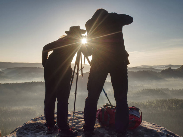 Two hikers taking pictures and talk on top of mountain. Two photographers  - Photo, Image