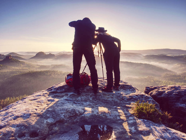 Two hikers taking pictures and talk on top of mountain. Two photographers  - Photo, Image