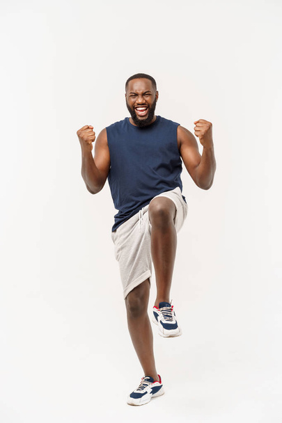 Young γυμναστήριο Αφρικάνικο μαύρο άντρα στο άθλημα φορούν επευφημίες ανέμελη και ενθουσιασμένη. Η ιδέα της νίκης. - Φωτογραφία, εικόνα