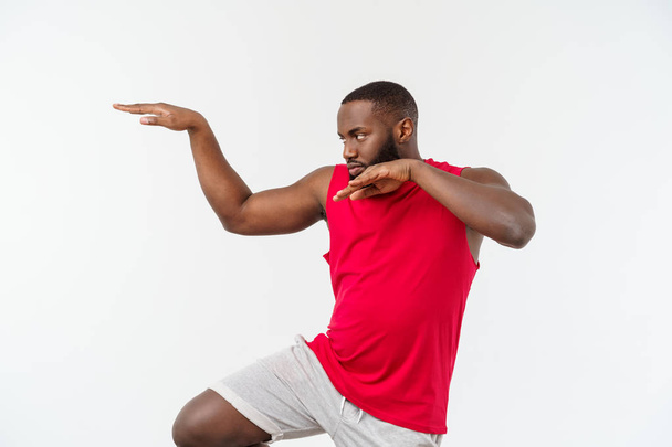 Funny and playful adult African American guy standing in profile in martial arts pose with raised palms, frowning and staring. - Fotografie, Obrázek