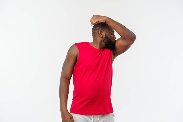 Adolescente afroamericano muestra músculos en el brazo. Aislado sobre fondo blanco. Retrato de estudio. Concepto de edad transitoria
 - Foto, imagen