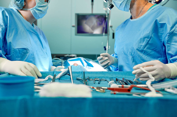 Uma equipe de cirurgiões de uniforme realiza uma operação em um paciente em uma clínica de cirurgia cardíaca. Medicina moderna, uma equipe profissional de cirurgiões, saúde
. - Foto, Imagem