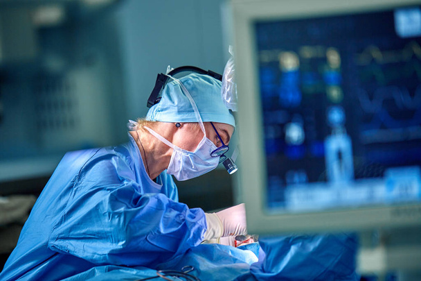 A surgeons team in uniform performs an operation on a patient at a cardiac surgery clinic. Modern medicine, a professional team of surgeons, health. - Photo, Image
