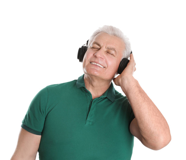 Mature man enjoying music in headphones on white background - Foto, Bild