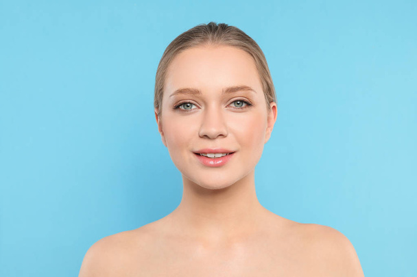 Portrait of young woman with beautiful face on blue background - Fotoğraf, Görsel