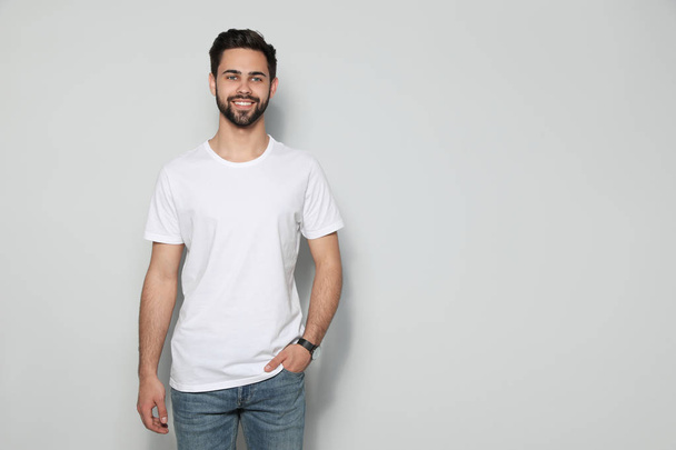 Young man in t-shirt on light background. Mock up for design - Fotoğraf, Görsel